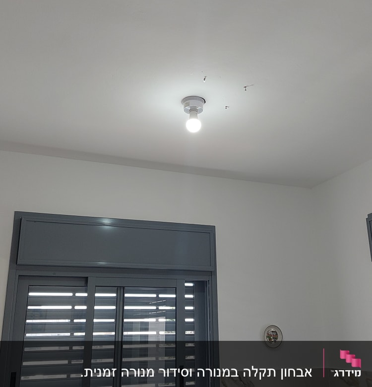 נורה דולקת בתקרה עם חוטי חשמל חשופים